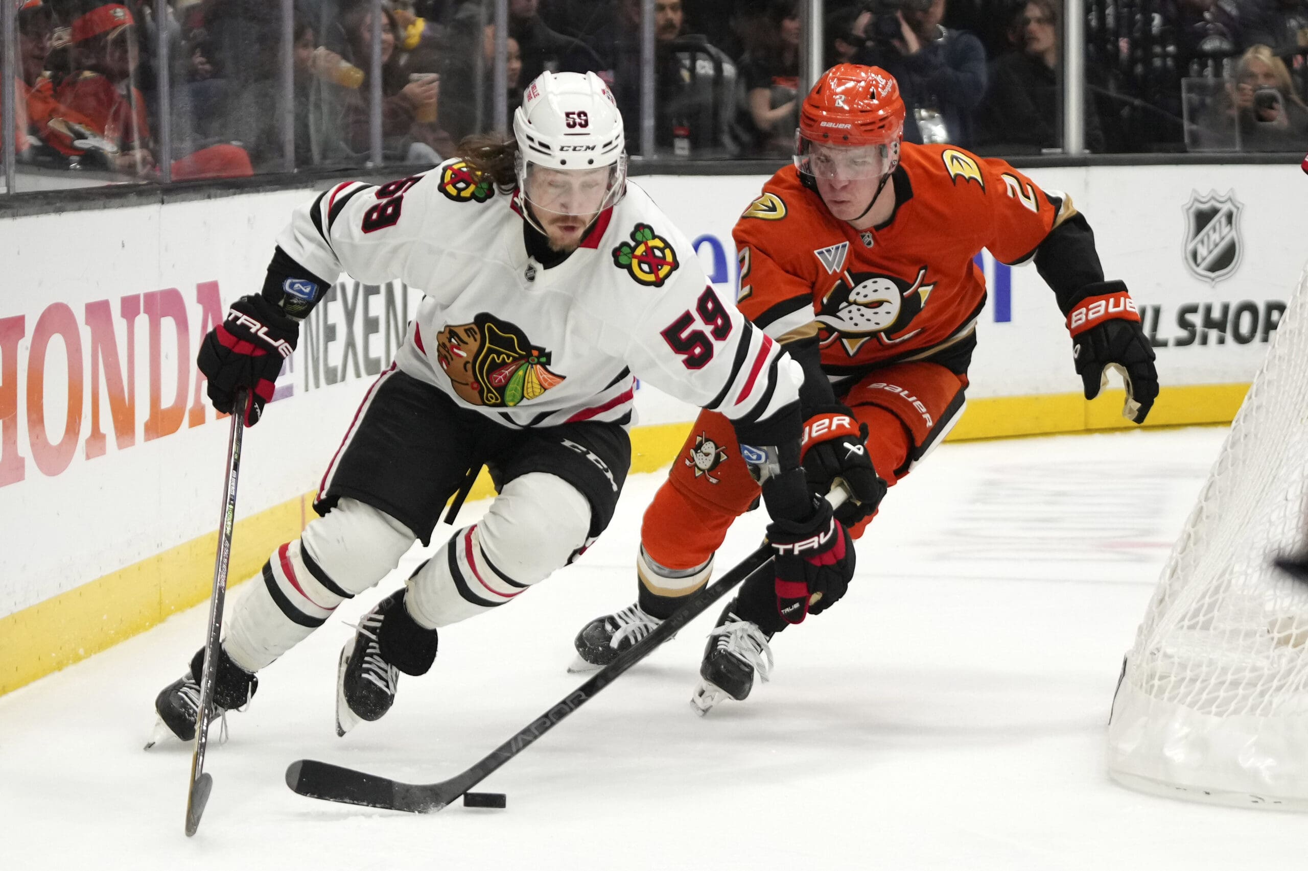 Chicago Blackhawks left wing Tyler Bertuzzi, left, takes the puck as Anaheim Ducks defenseman Jackson LaCombe reaches in during the second period of an NHL hockey game, Sunday, Nov. 3, 2024, in Anaheim, Calif. (AP Photo/Mark J. Terrill)