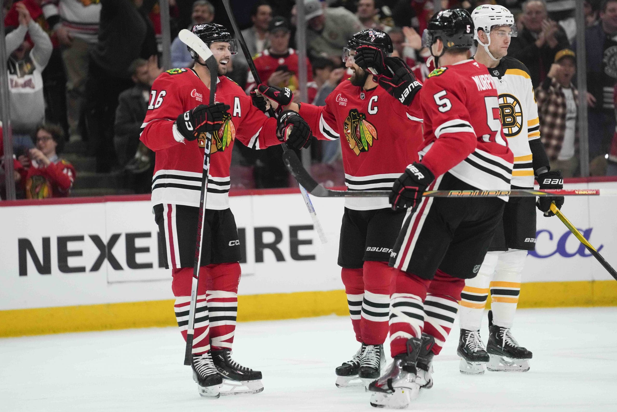 Chicago Blackhawks center Jason Dickinson, left, celebrates his goal on the Boston Bruins with left wing Nick Foligno (17) and defenseman Connor Murphy (5) during the second period of an NHL hockey game Wednesday, Dec. 4, 2024, in Chicago. (AP Photo/Erin Hooley)